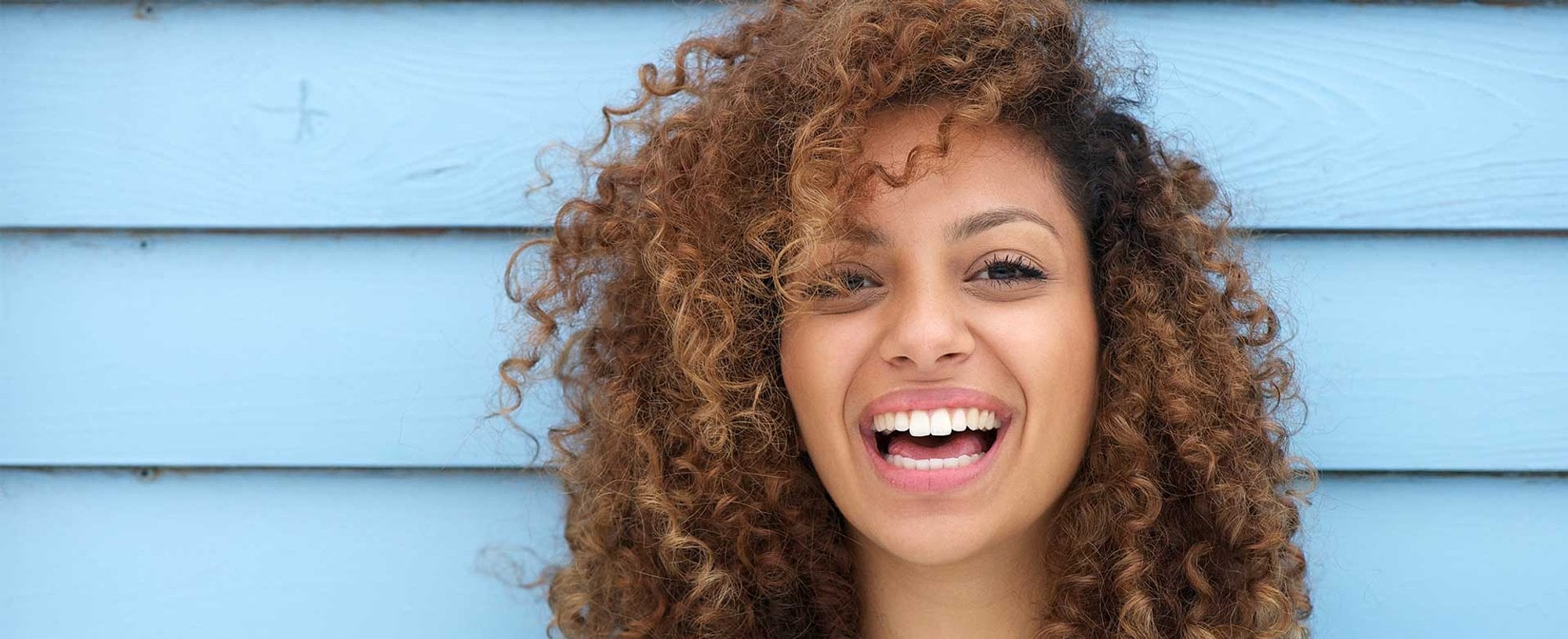 Mulher sorrindo com cabelos castanhos claro