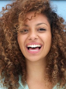 Mulher sorrindo com cabelos castanhos claro