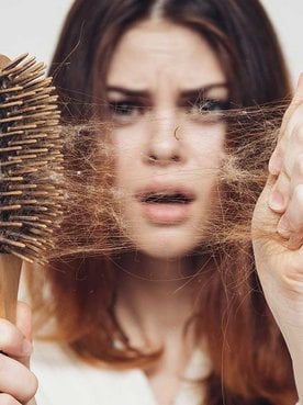 Modelo tirando seus cabelos da escova