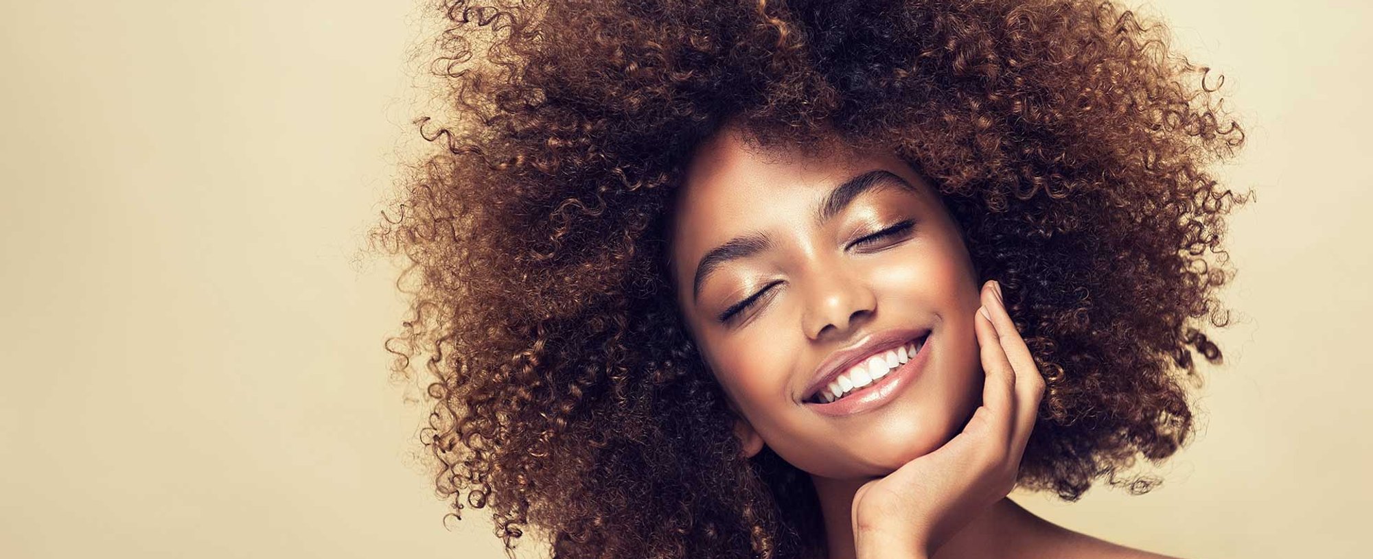 Modelo morena com cabelos cacheados e volumosos