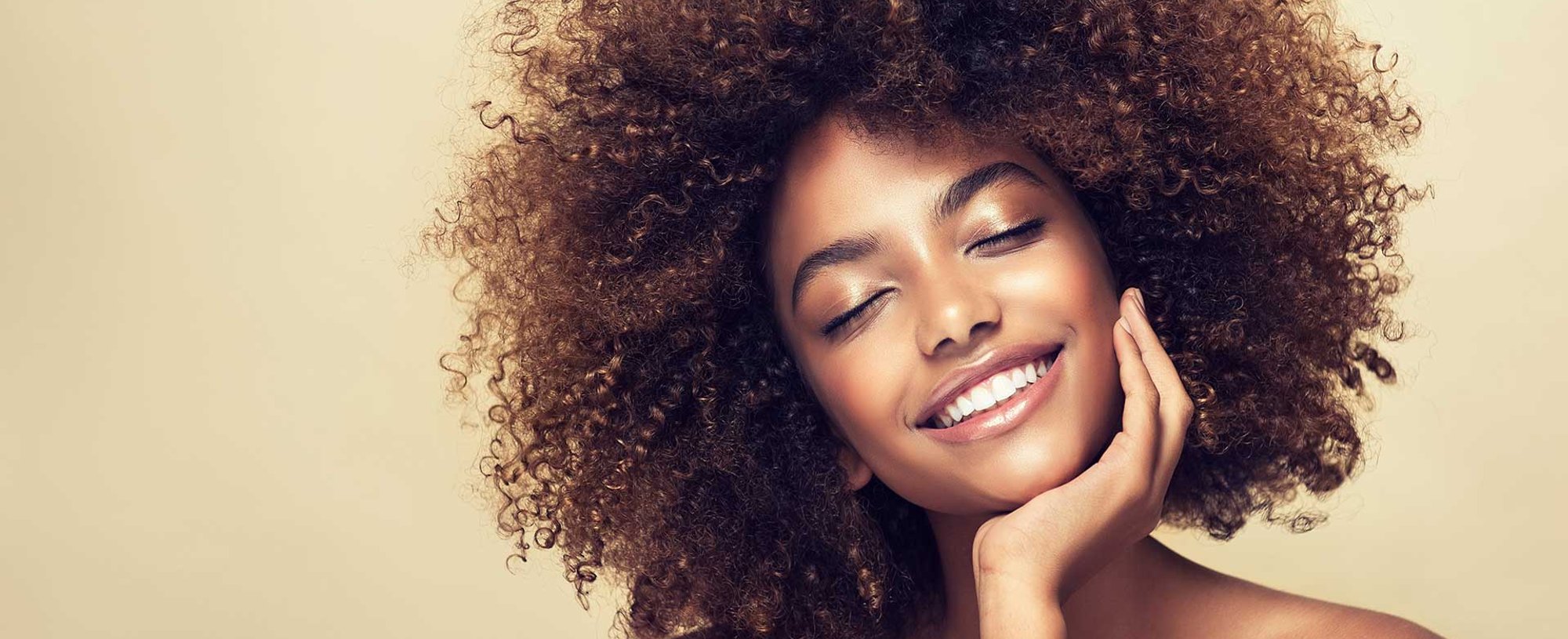 Modelo morena com cabelos cacheados e volumosos