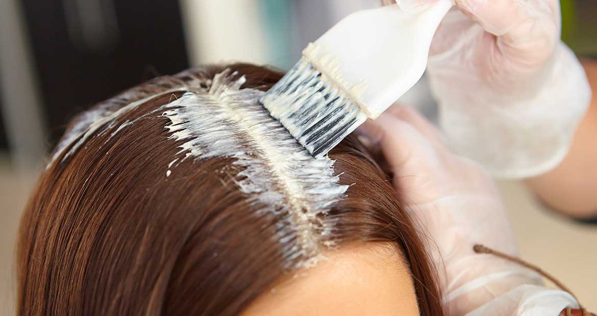 Modelo passando produto em seus cabelos