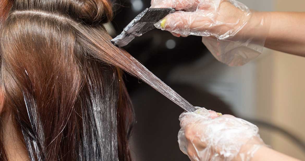 Modelo passando produto em seus cabelos