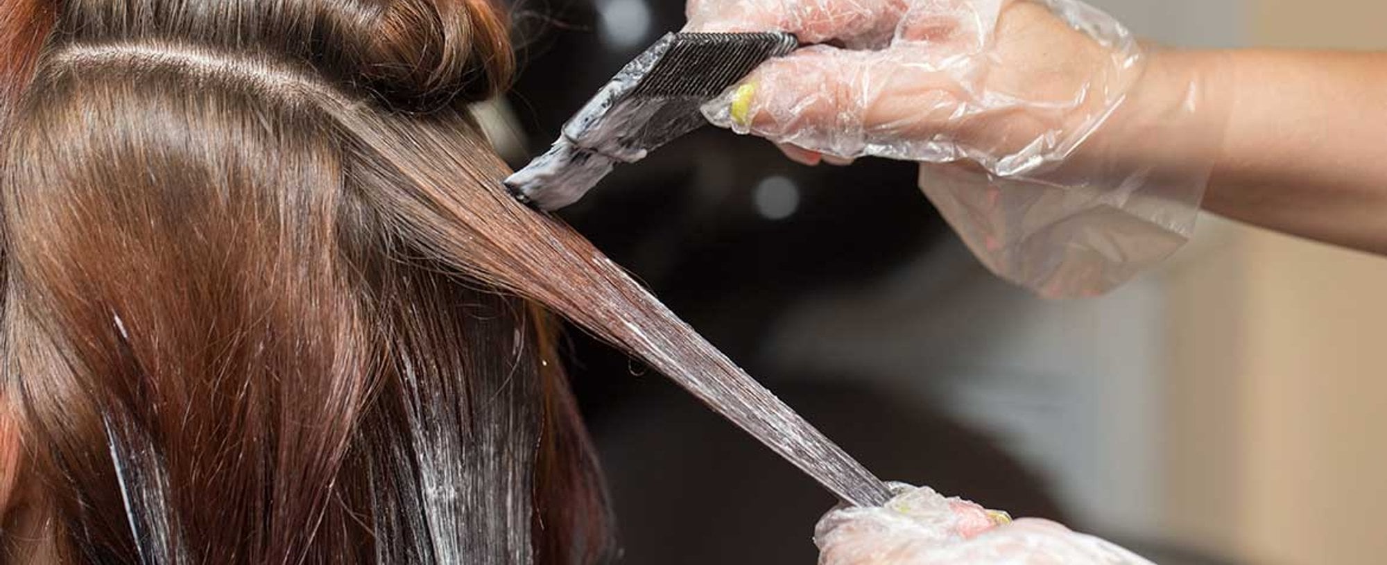 Modelo passando produto em seus cabelos castanhos