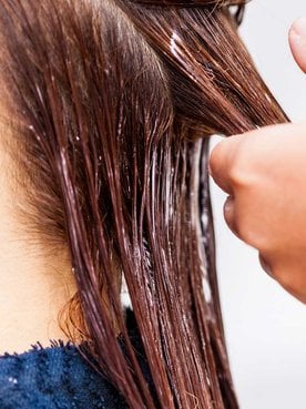 Modelo tendo seu cabelo cuidado