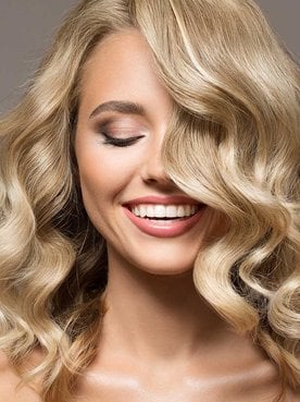 Modelo com cabelo loiro e curto levemente ondulado