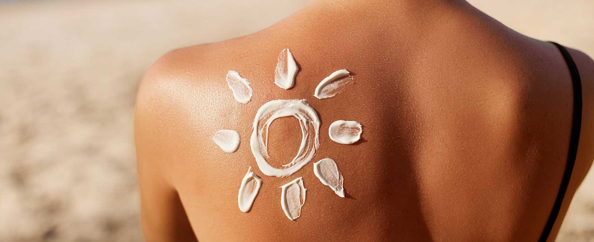 Modelo passando protetor solar em seu rosto