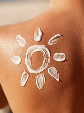 Modelo passando protetor solar em seu rosto