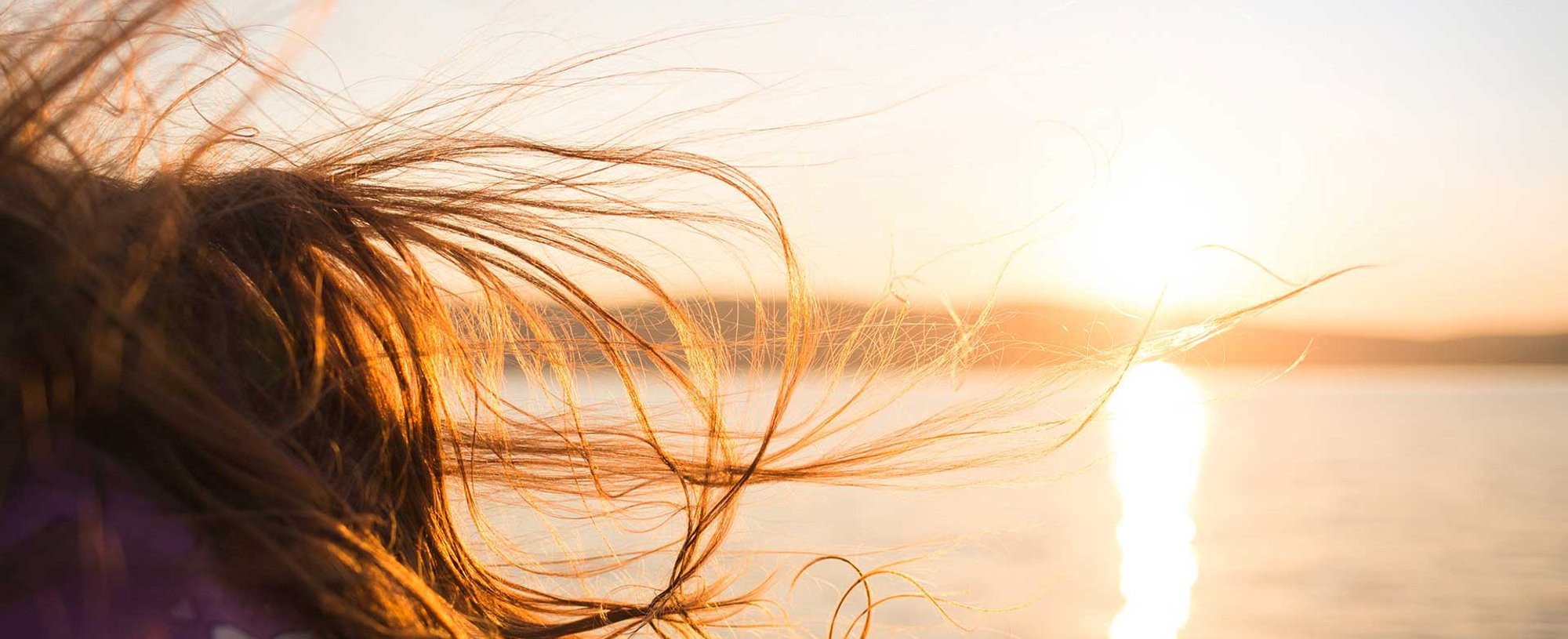 Mulher Com Cabelo Castanho Ao Vento Com Sol No Fundo