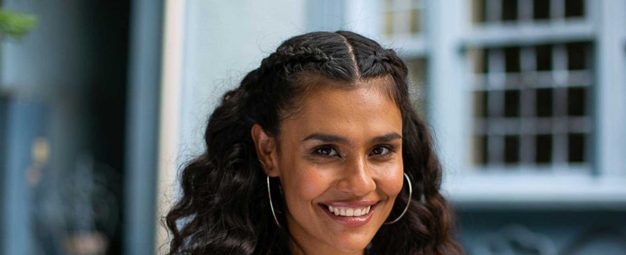 Modelo sorrindo com cabelo semi preso com trana embutida