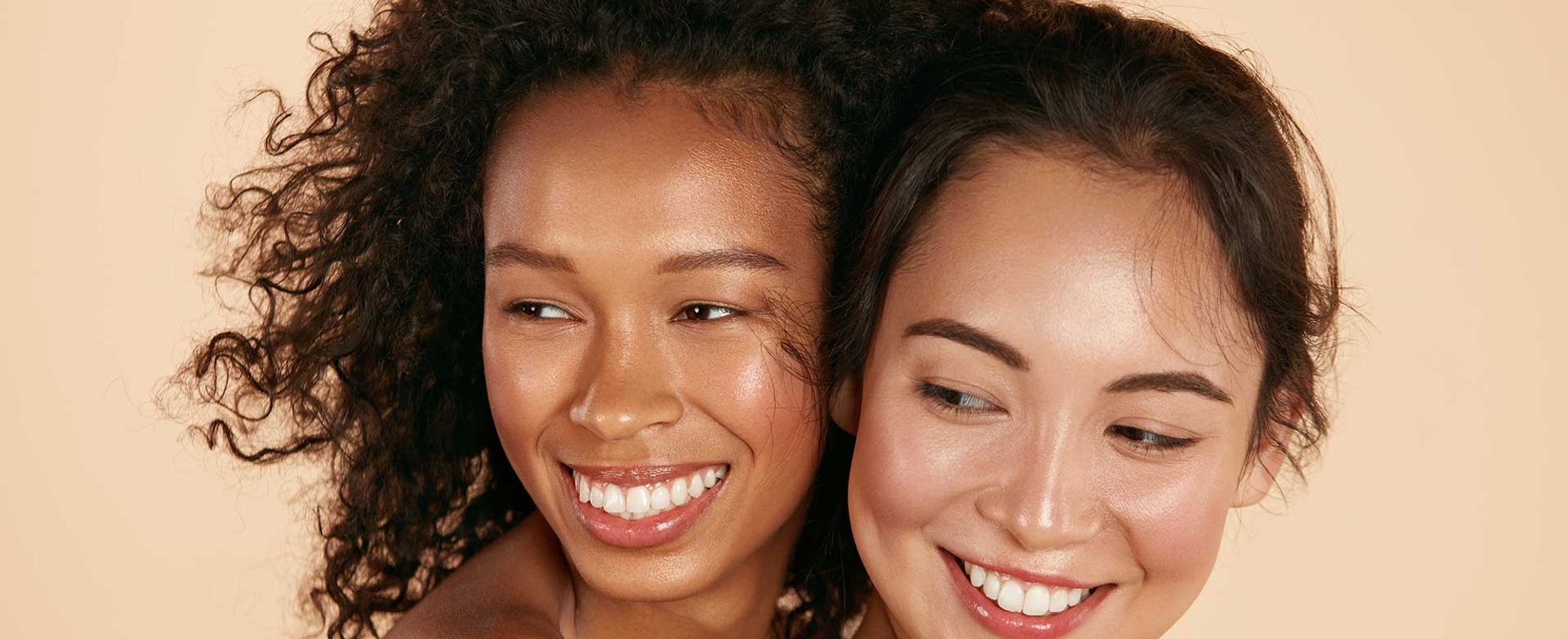 Duas Modelos Uma Morena Cacheada E Uma Asitica Ambas Sorrindo