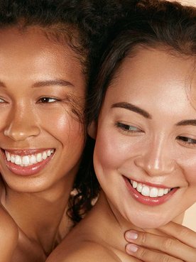 Duas Modelos Uma Morena Cacheada E Uma Asitica Ambas Sorrindo