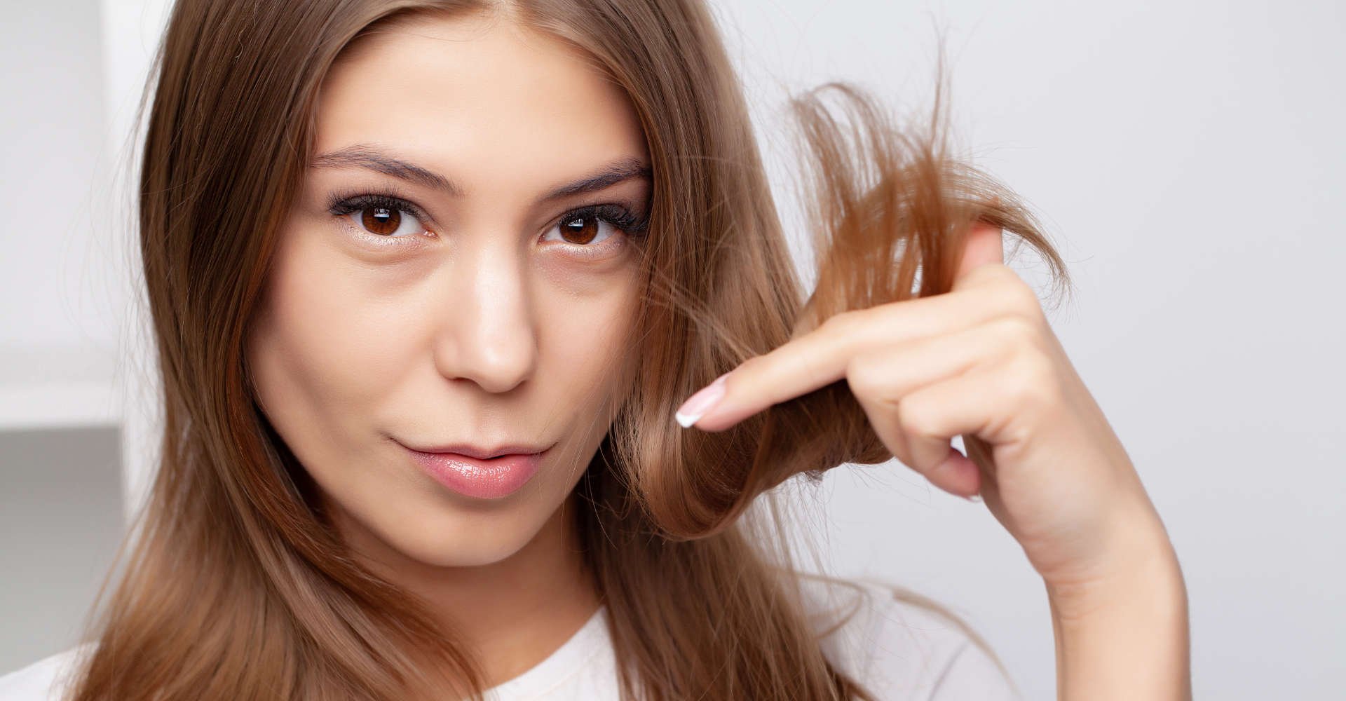 mulher exibe ponta dos cabelos danificadas