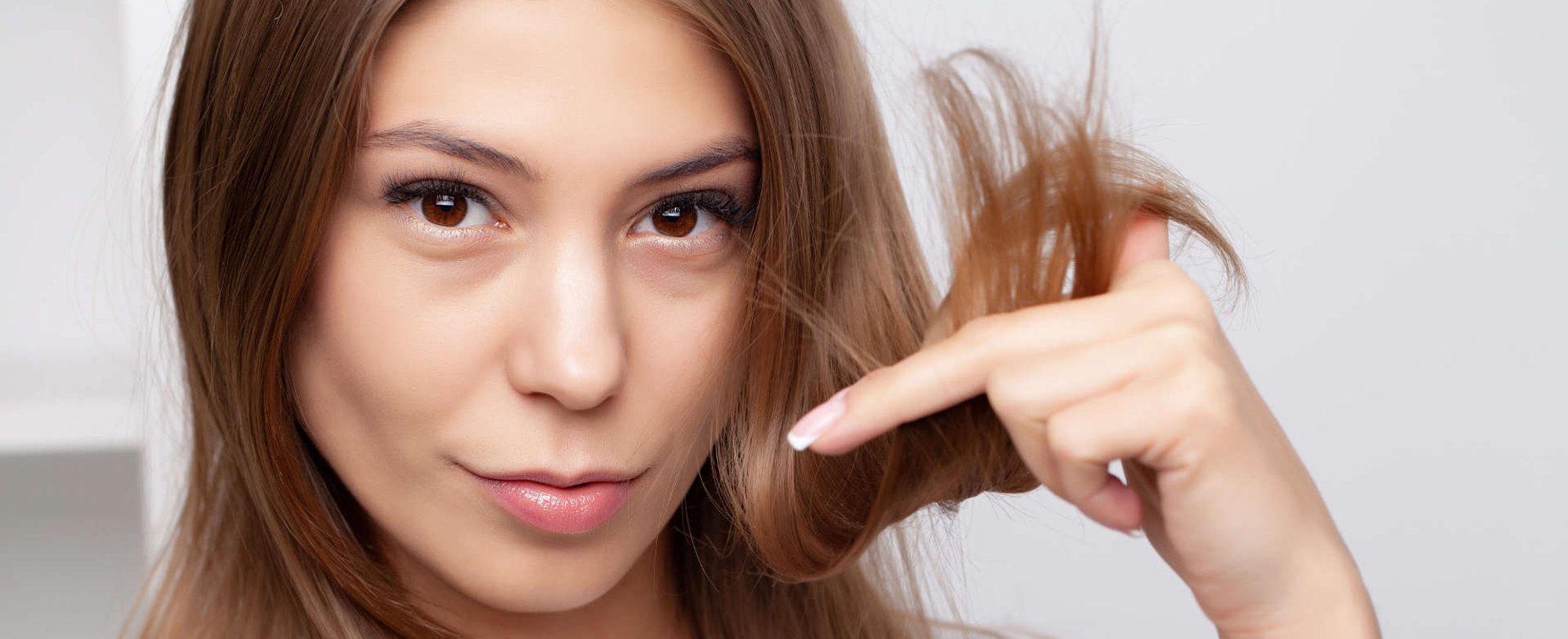 mulher exibe ponta dos cabelos danificadas