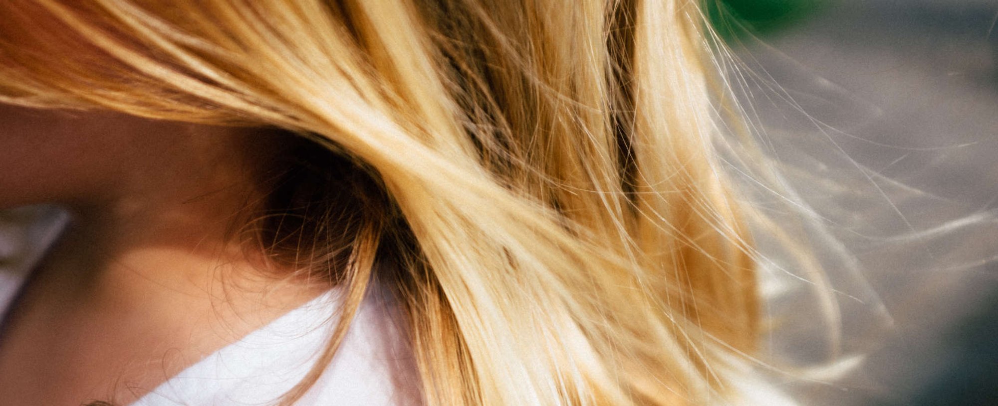 mulher exibe cabelos loiros  bem brilhantes