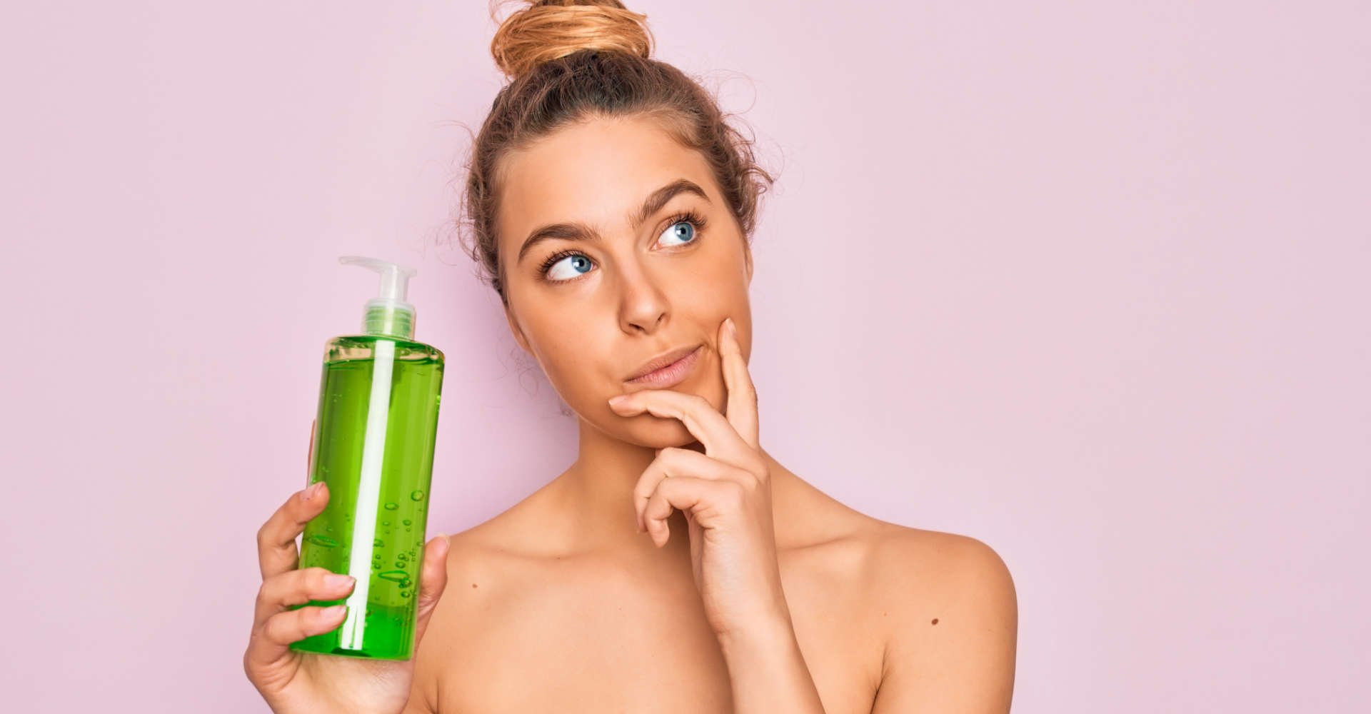 mulher segura shampoo/condicionador parecendo se questionar