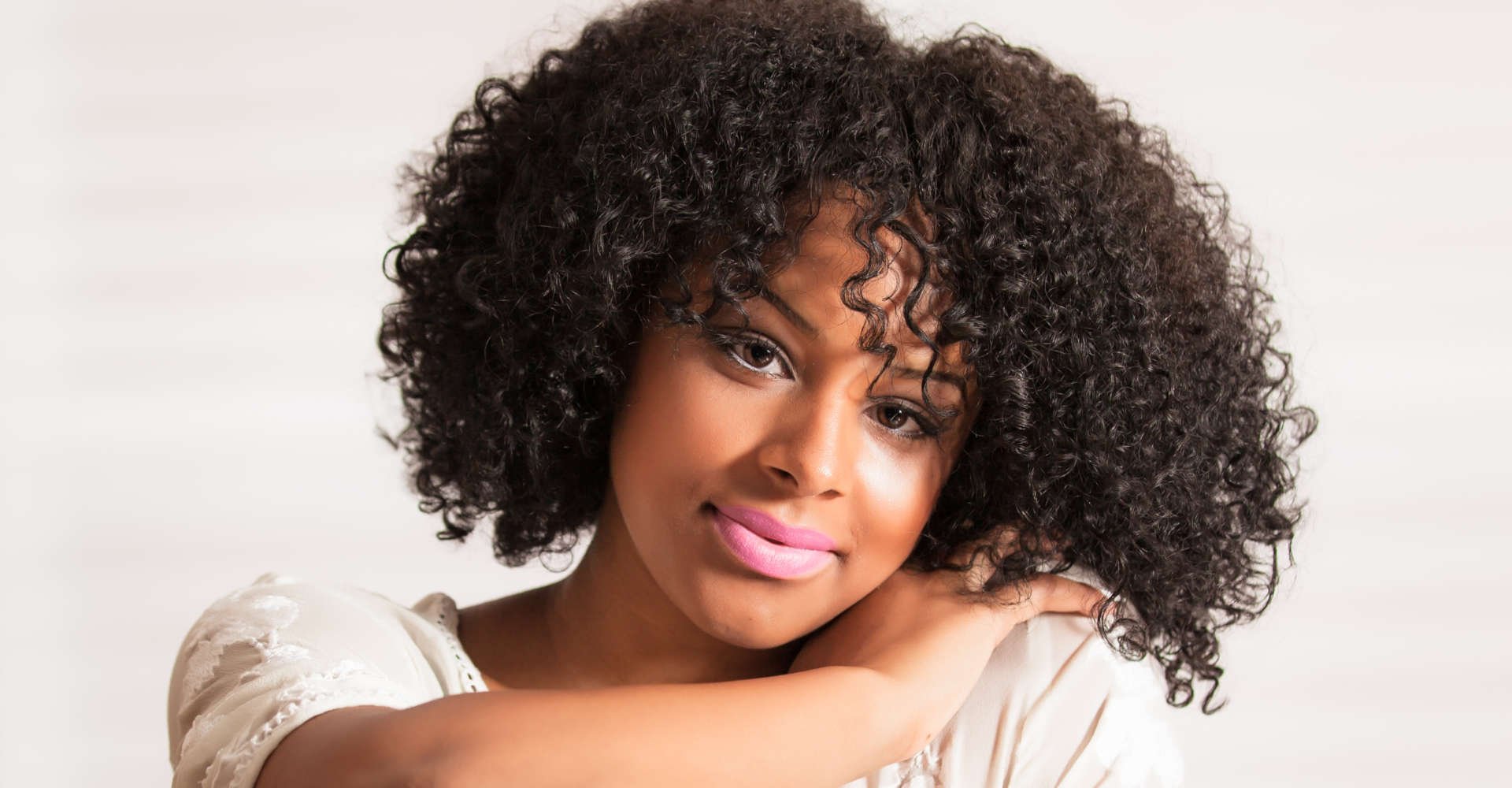 mulher exibe cabelo cacheado 