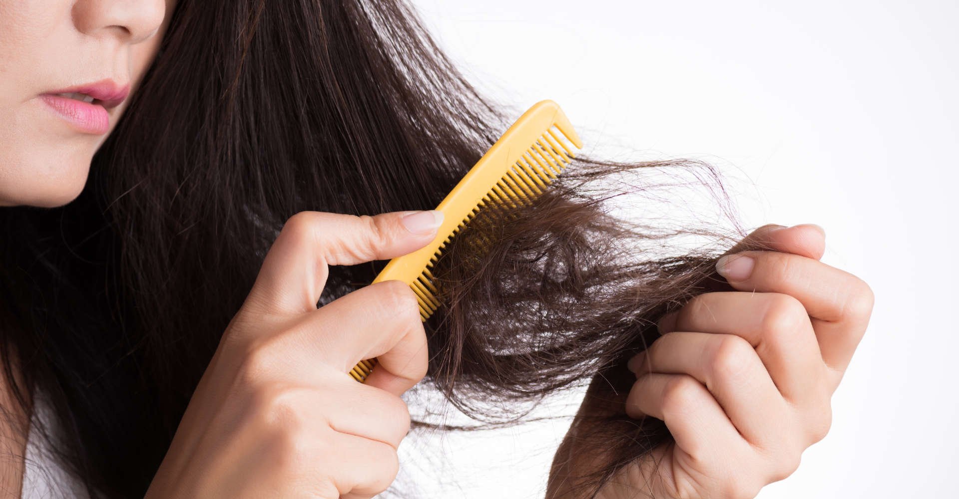 mulher tenta pentear com um pente os cabelos danificados com pontas duplas