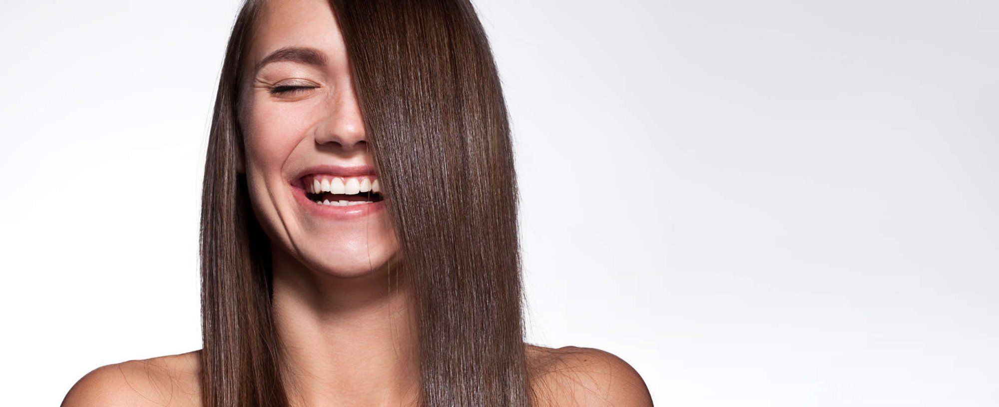 mulher sorri com seu cabelo liso