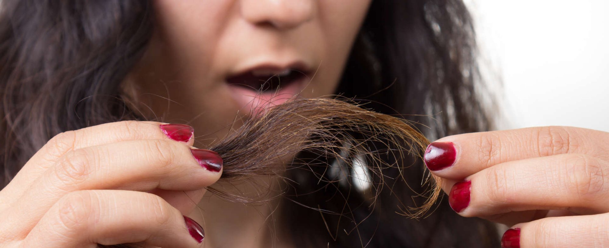 mulher espantada com as pontas duplas do cabelo