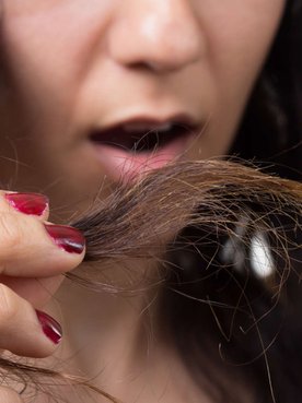 mulher espantada com as pontas duplas do cabelo