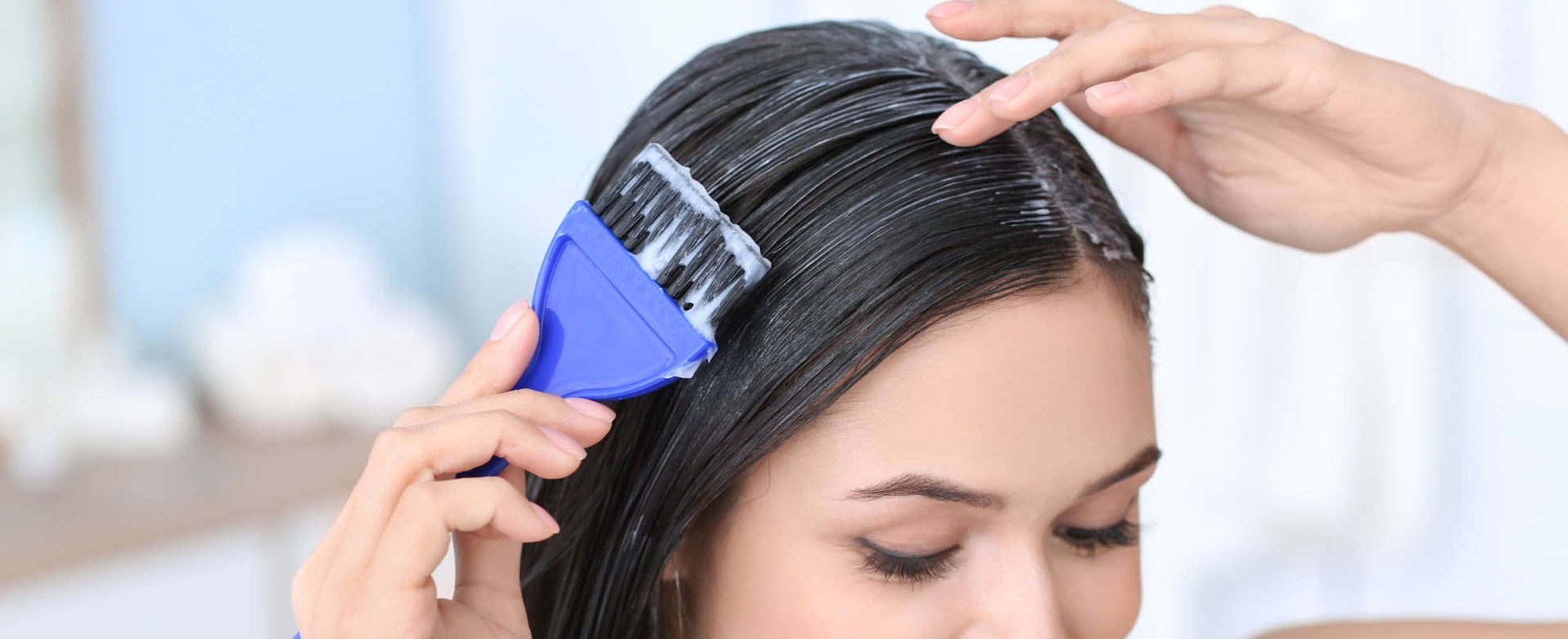 mulher passando creme no cabelo