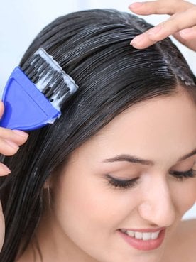 mulher passando creme no cabelo