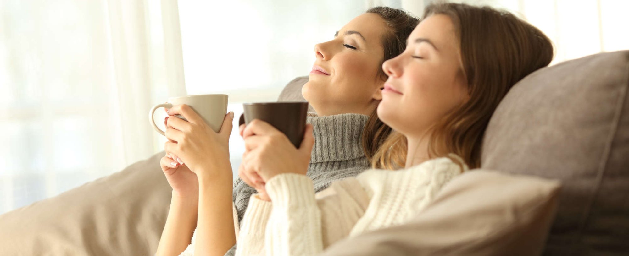 mulheres tomam café relaxando no sofá