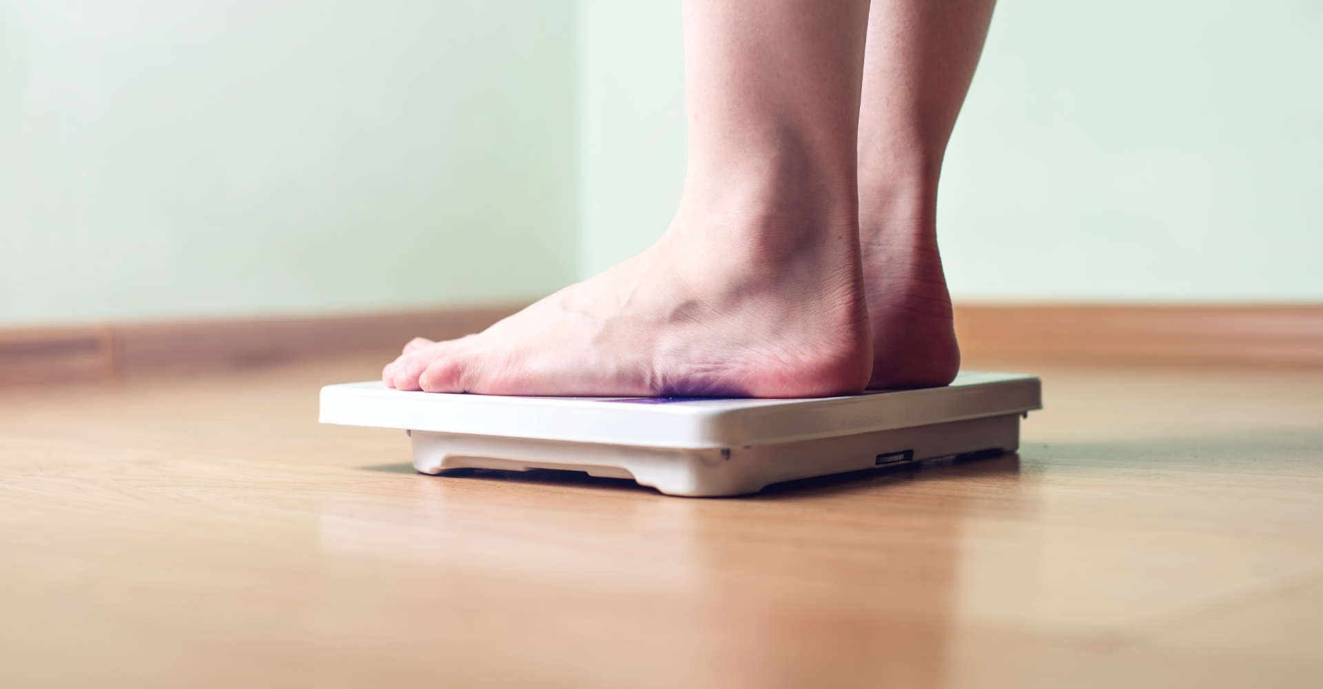 mulher conferindo o peso na balança