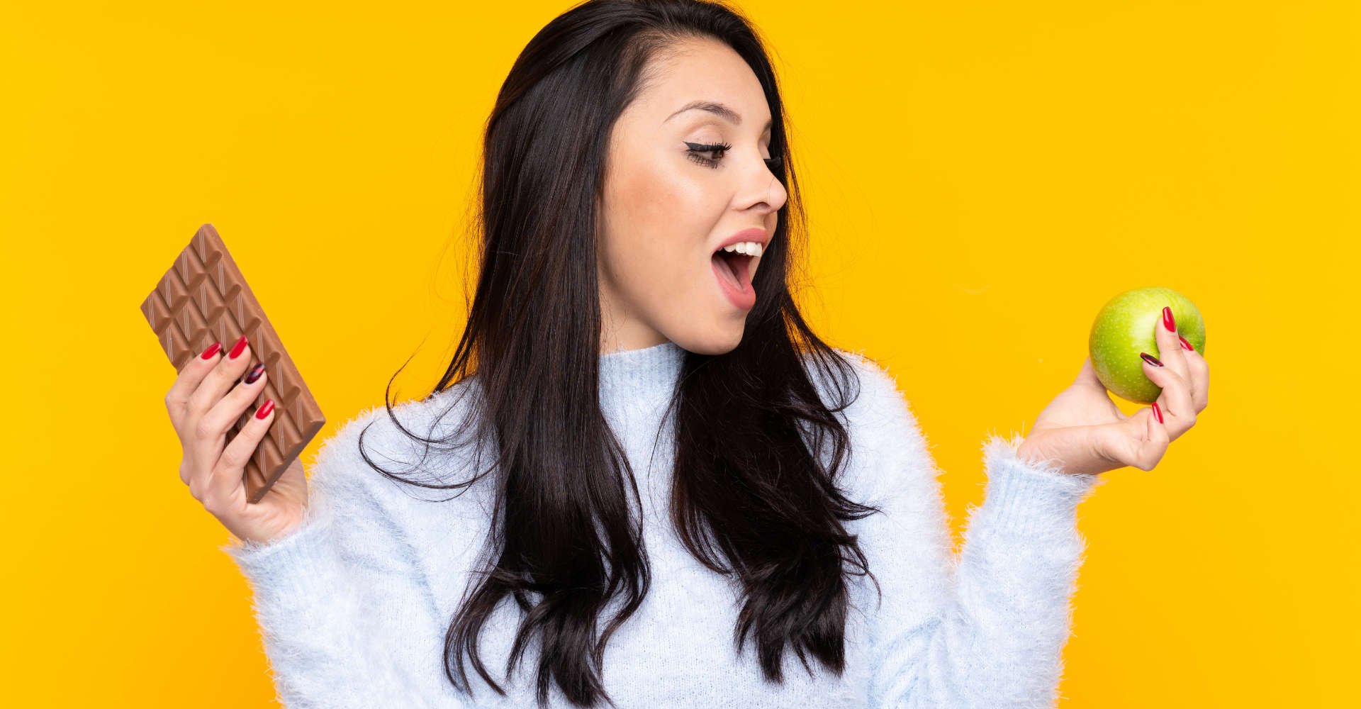 mulher segurando chocolate e fruta