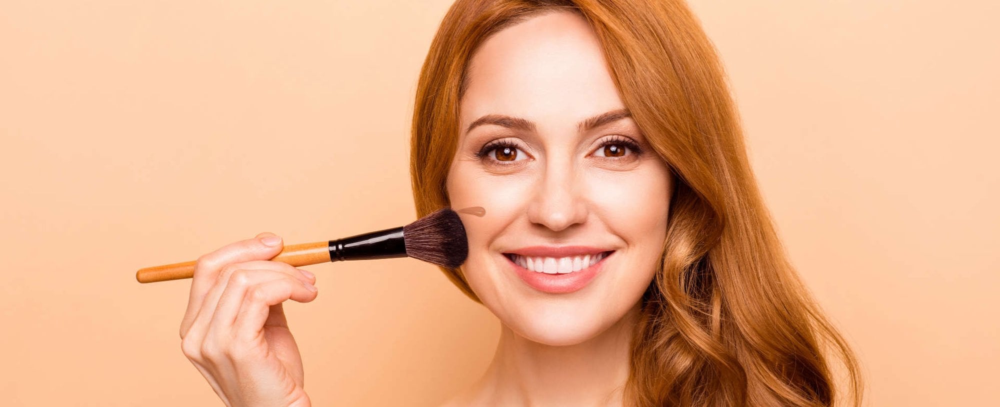 mulher passando creme base no rosto, "bb cream"