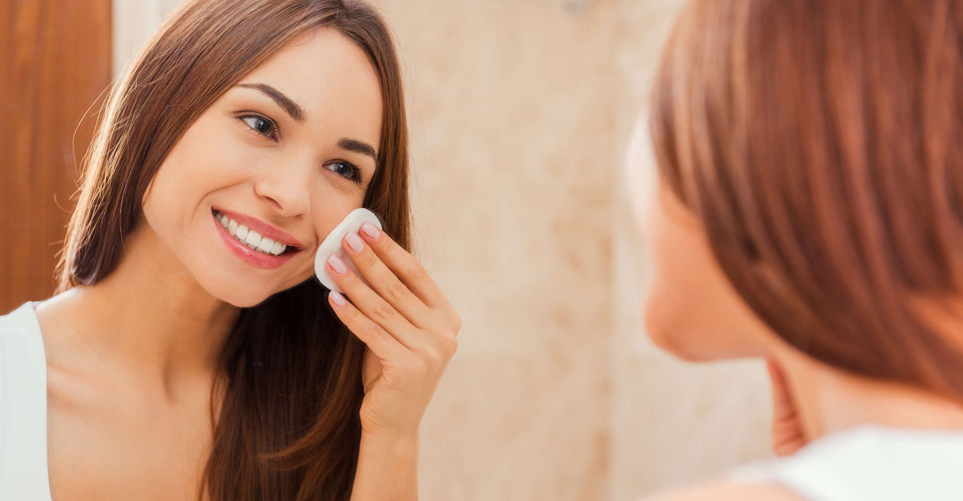 mulher fazendo a limpeza do rosto com água micelar