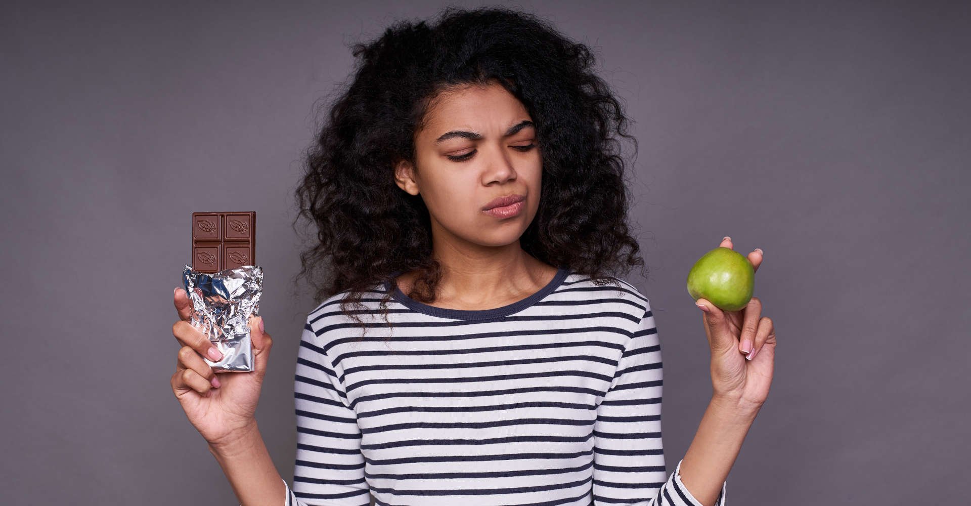 mulher indecisa sobre qual alimento escolher