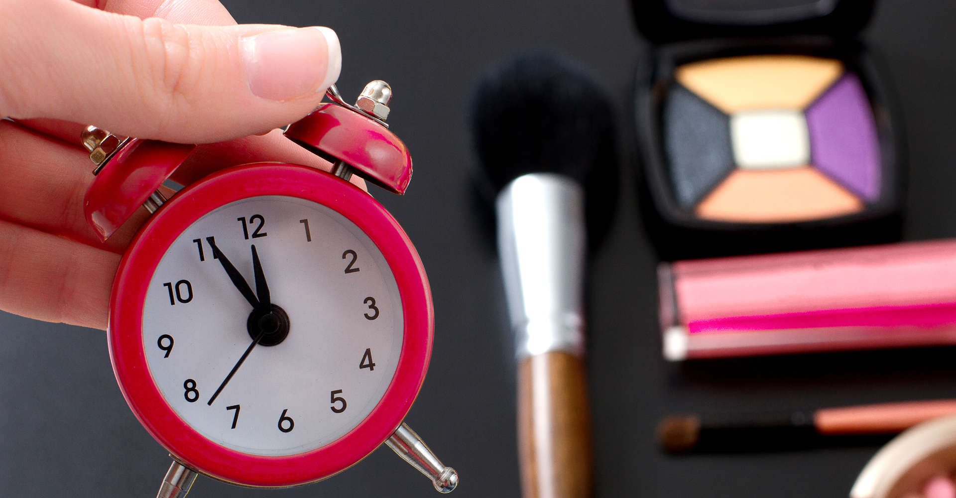 relógio em frente a uma mesa com vários acessórios de maquiagem