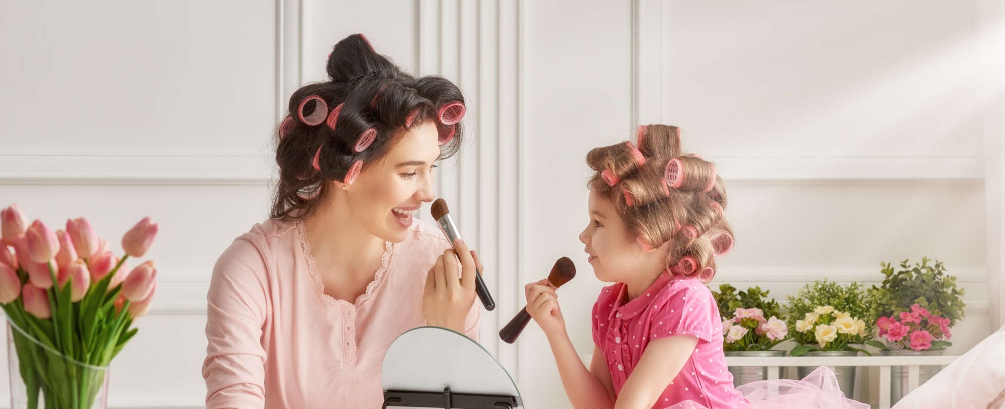 mãe e filha passando base no rosto