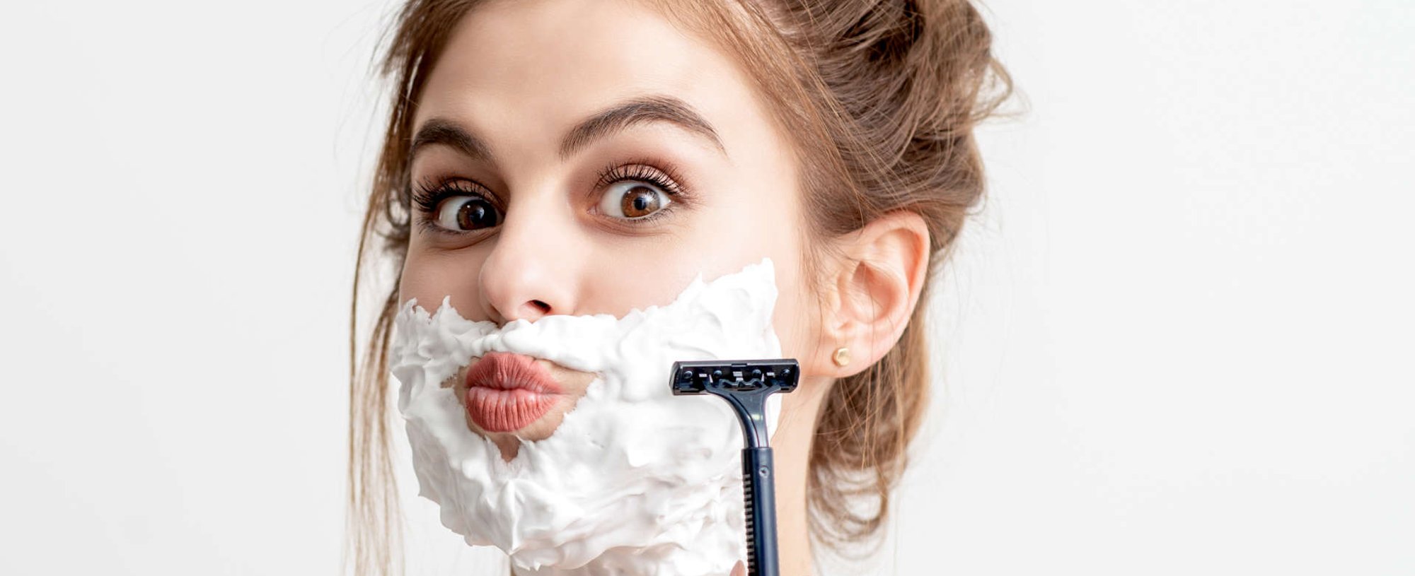 mulher raspando o rosto com um aparelho de barba