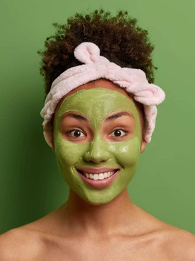 mulher exibe o rosto com máscara verde