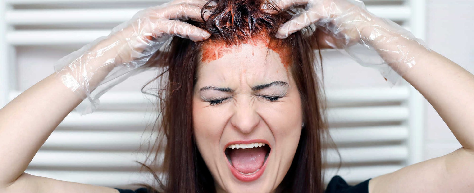 Modelo branca pintando o cabelo de vermelho