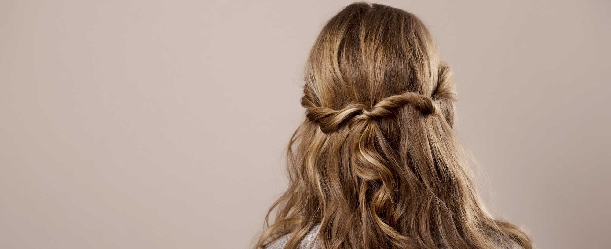 Modelo loira de costas com cabelo trançado