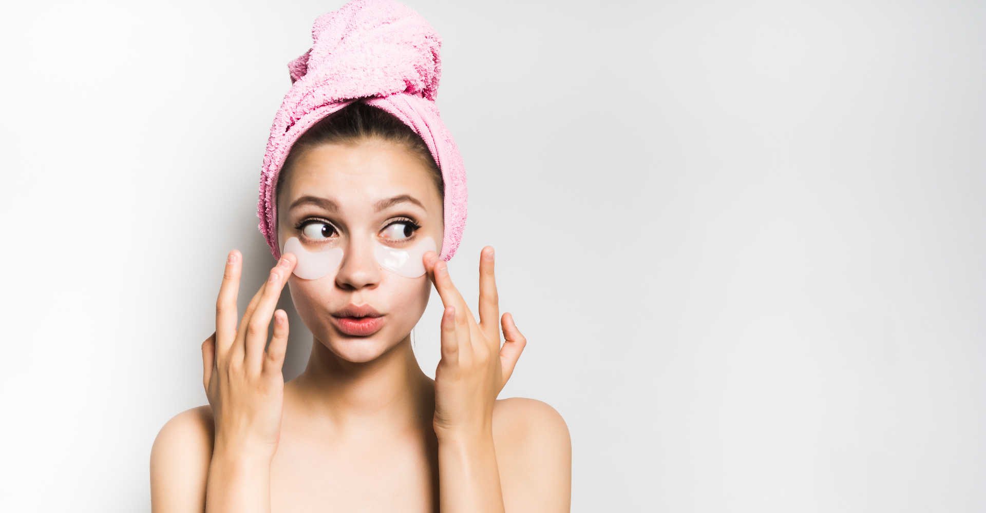 Modelo branca com toalha no cabelo e creme no rosto