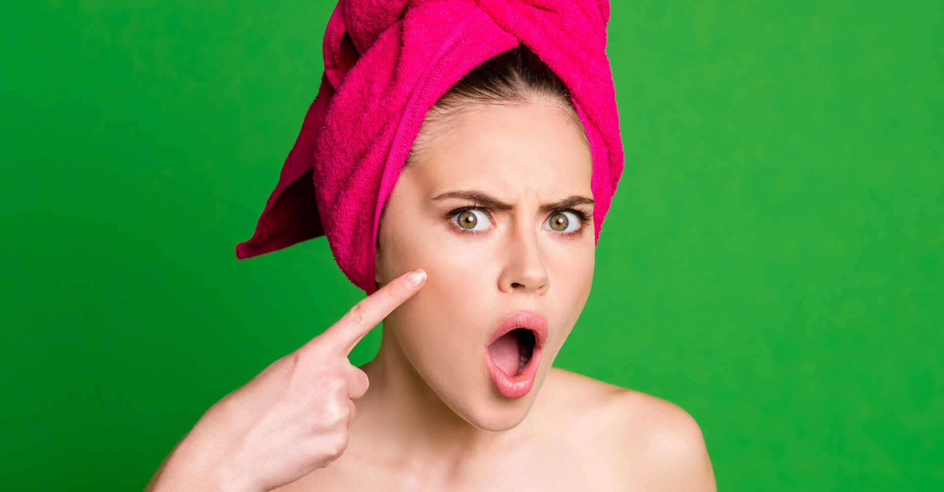 Modelo branca com toalha no cabelo a apontando o dedo para seu rosto