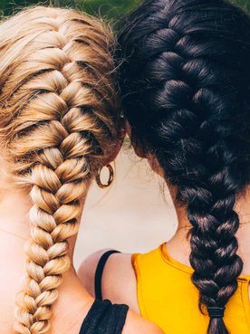 Duas modelos, uma loira e outra morena com tranças