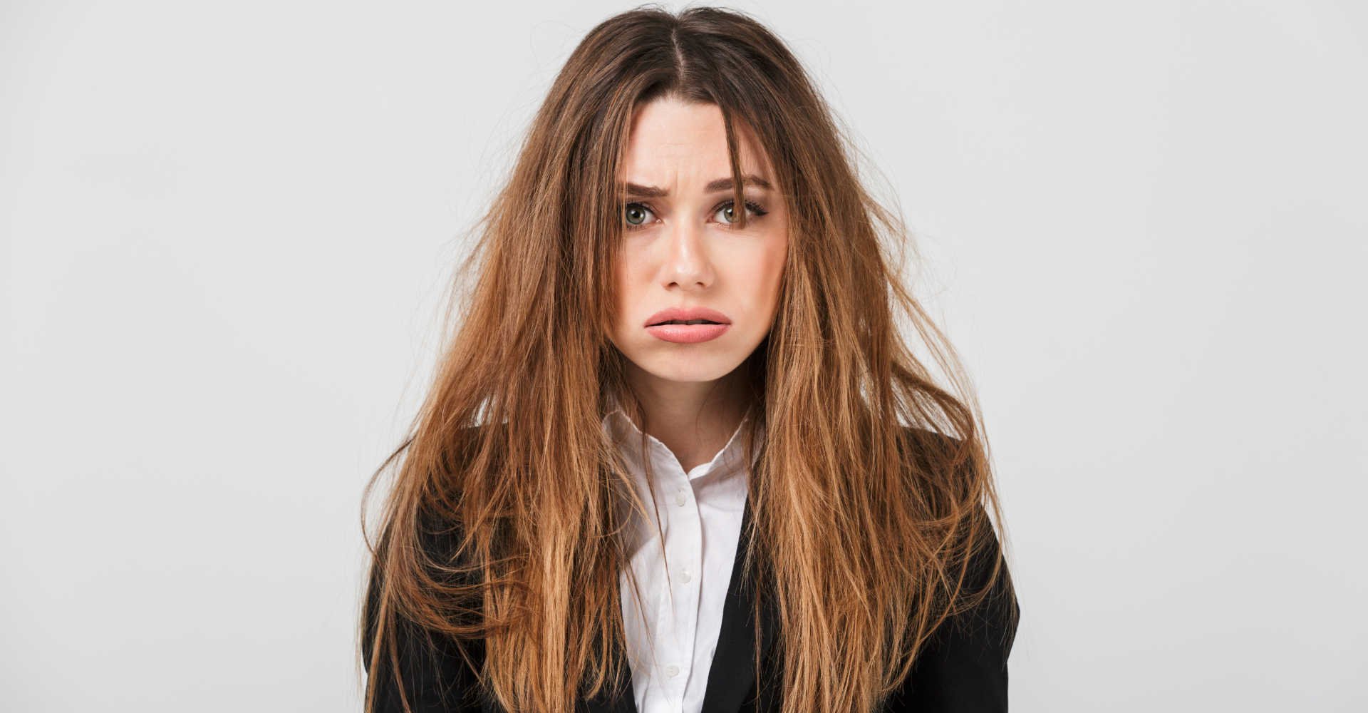 Modelo branca com expressão de tristeza com os cabelos danificados