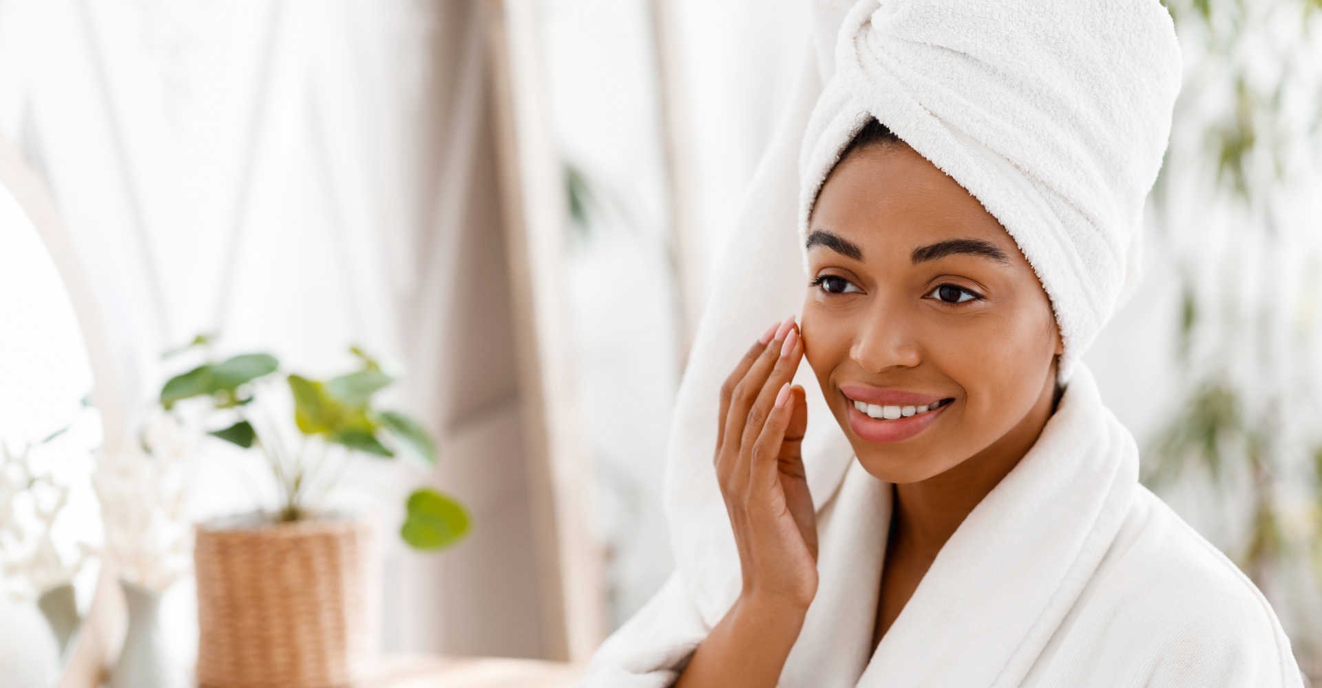 Modelo negra passando creme no rosto