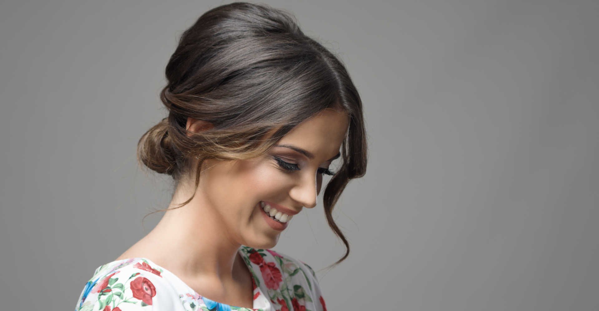 Modelo branca sorrindo com penteado coque