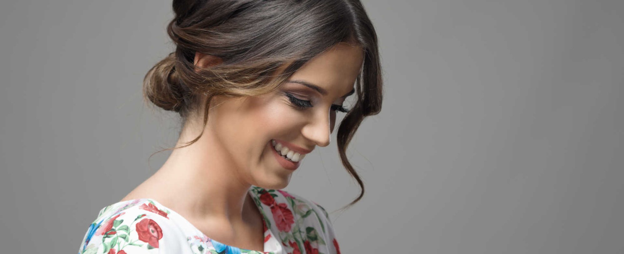 Modelo branca sorrindo com penteado coque