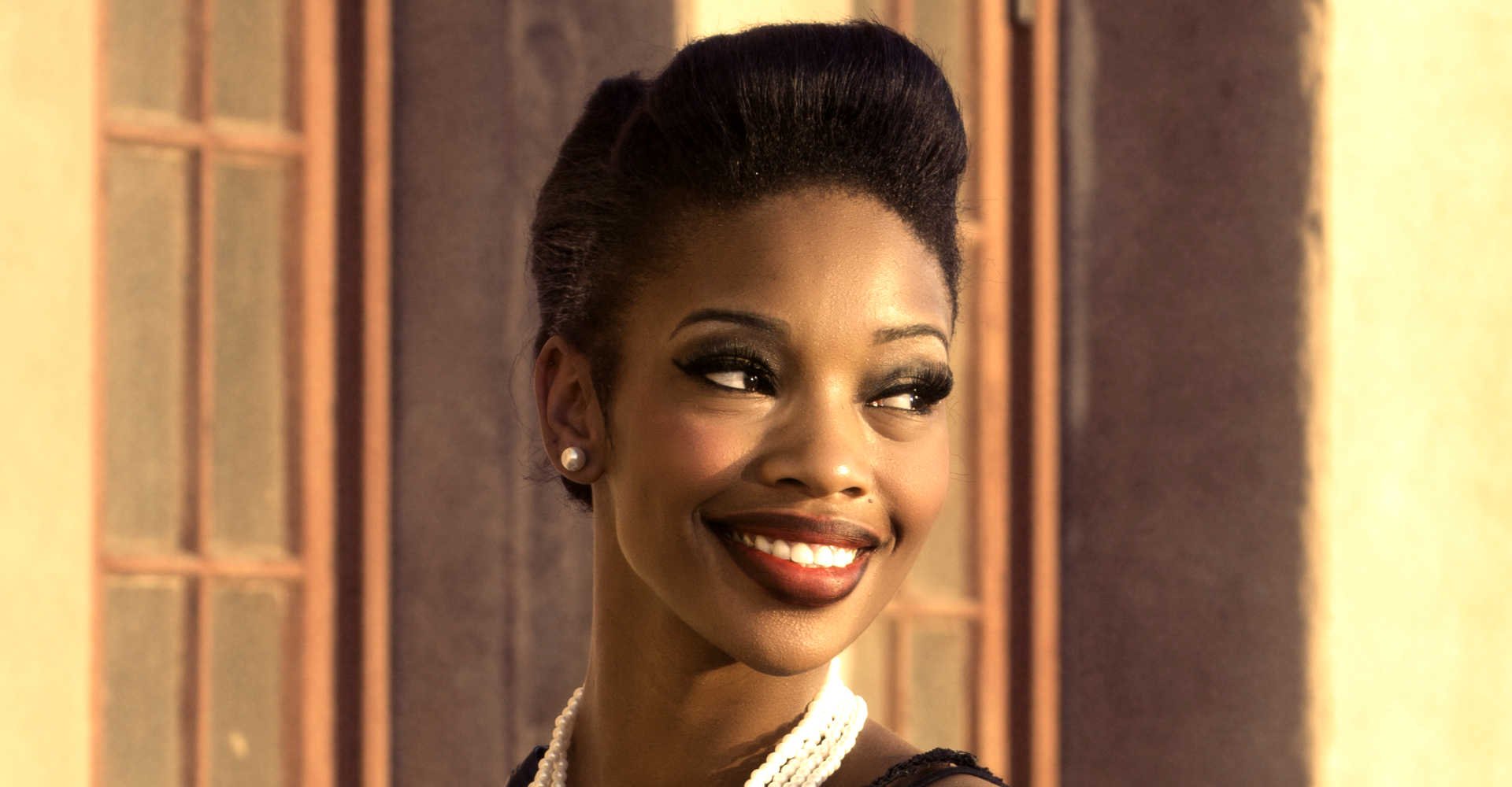 Modelo negra sorrindo com topete