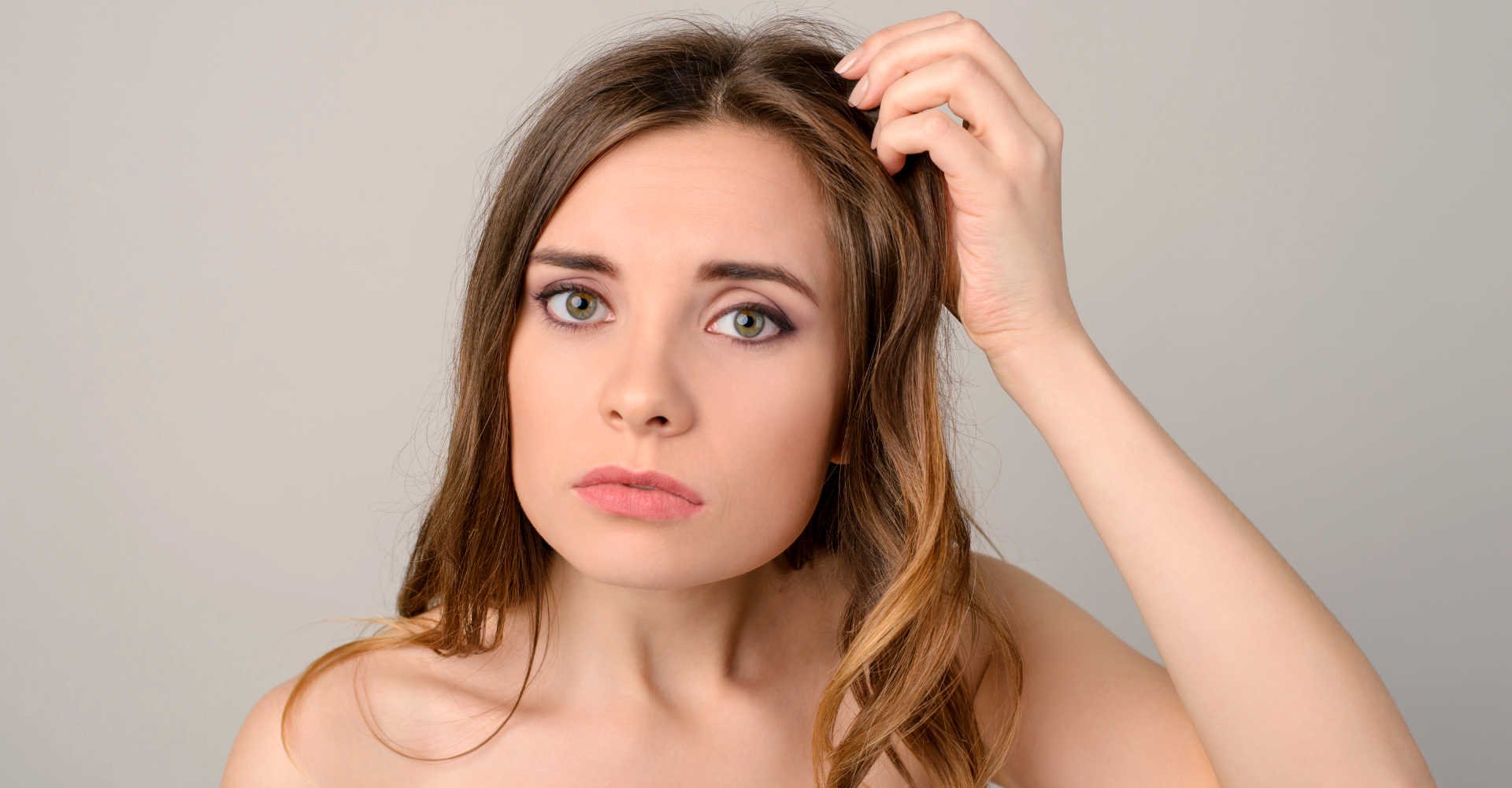 Modelo branca com a mão no cabelo