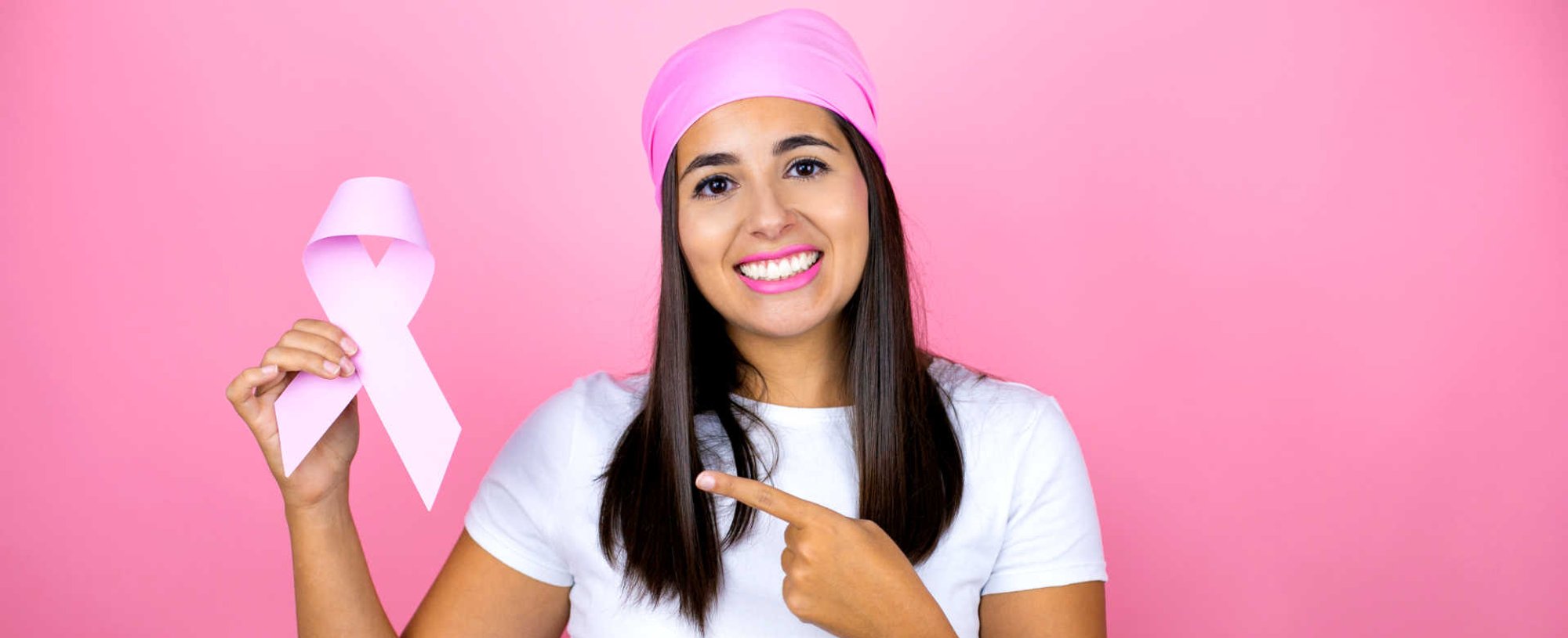 Modelo branca com pano rosa no cabelo em campanha do outubro rosa