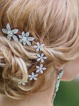 Cabelo loiro com coque e acessório metalico